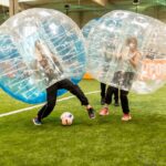 Kinder spielen Bubble Soccer auf einem Fussballfeld in Zürich – BubbleBall Schweiz mieten